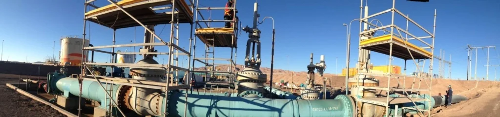 Sistema de tuberías y estanques industriales durante proceso de limpieza y certificación en faena industrial.