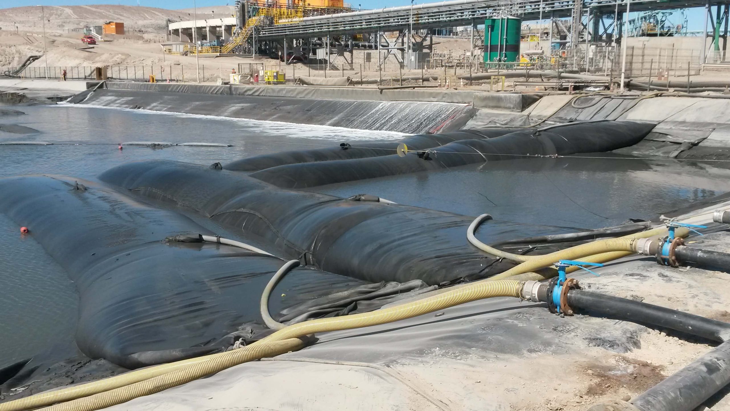 Geotubos instalados en una piscina industrial para el deshidratado de sedimentos y la recuperación de minerales mediante separación sólido-líquido.